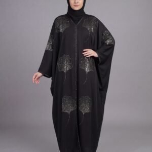A full-length studio photograph of a woman wearing a flowing, wide-cut grey kaftan-style abaya from Malik Abaya, set against a solid grey background. The abaya is made from Imported Tik Tok fabric and is beautifully adorned with large, structured fan-shaped silver sequin, bead, and stone patches on the shoulders, torso, and lower skirt, connected by delicate silver embroidered lines. The model wears a plain black hijab.
